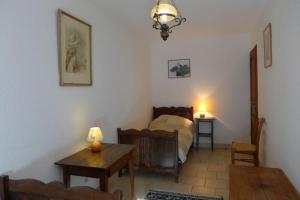 ein Schlafzimmer mit einem Bett und einem Tisch in einem Zimmer in der Unterkunft Le paradis des goncourt in Goncourt