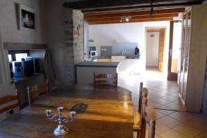 een keuken en eetkamer met een houten tafel en een keuken bij Les jardins de recourt in Récourt +7 foto's