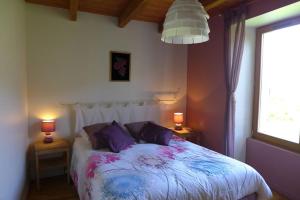 een slaapkamer met een bed met twee lampen en een raam bij Les jardins de recourt in Récourt