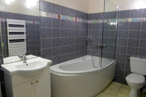 een badkamer met een bad, een wastafel en een toilet bij Les jardins de recourt in Récourt