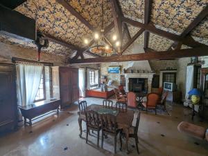 een woonkamer met een tafel, stoelen en een open haard bij Villa antigone in Vaux-sous-Aubigny