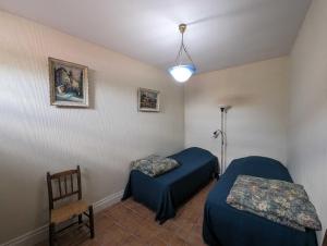 een kamer met 2 bedden en een stoel en een lamp bij Villa antigone in Vaux-sous-Aubigny