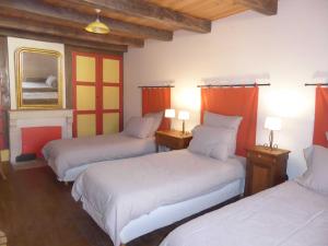 une chambre avec trois lits et des rideaux orange dans l'établissement Eco gite de la rainette, à Chantraines