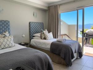 una camera da letto con due letti e un balcone di Aquarella 15 a Plettenberg Bay