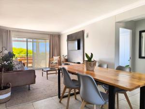 una sala da pranzo con tavolo e sedie in legno di Aquarella 15 a Plettenberg Bay