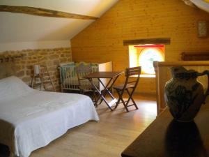 une chambre avec un lit, une table et des chaises dans l'établissement Le routoir, à Fayl-Billot