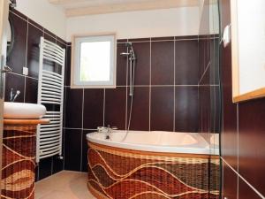 une salle de bain avec une baignoire et un lavabo dans l'établissement Le routoir, à Fayl-Billot