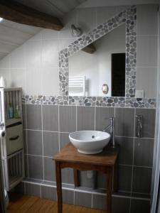 une salle de bains avec un lavabo et un miroir dans l'établissement Le routoir, à Fayl-Billot