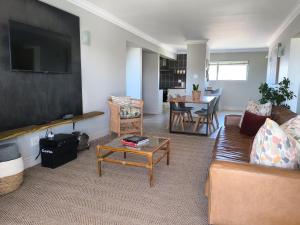 un soggiorno con un divano e un tavolo di Aquarella 15 a Plettenberg Bay