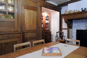 ein Esszimmer mit einem Tisch und einem Holzschrank in der Unterkunft Gite de la fontaine in Saint-Blin + 25 Fotos