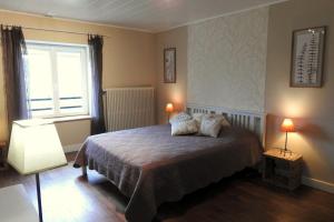 ein Schlafzimmer mit einem Bett mit zwei Lampen und einem Fenster in der Unterkunft Gite de la fontaine in Saint-Blin