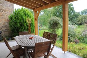 ein Holztisch und Stühle auf einer Terrasse in der Unterkunft Gite de la fontaine in Saint-Blin