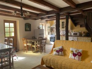 een keuken en woonkamer met een bank en een tafel bij La verte vallee in Orbigny-au-Val