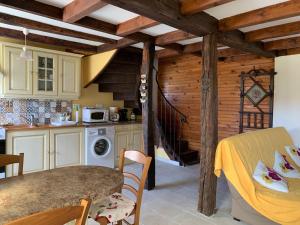 een keuken met een eettafel en een trap bij La verte vallee in Orbigny-au-Val