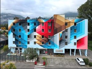 a building with a painting on the side of it at Ekho Hotel Grenoble Nord Saint Egrève in Saint-Égrève