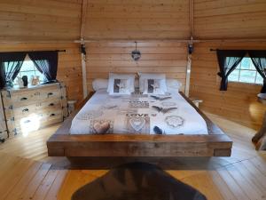 a bedroom with a large bed in a log cabin at Chambre Insolite L'écureuil in Coligny +12 photos