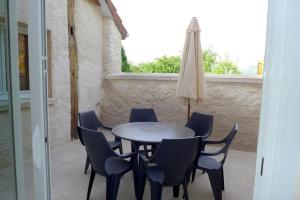 - une table, des chaises et un parasol sur la terrasse dans l'établissement Les jonquilles, à Vignes-la-Côte 3 autres photos