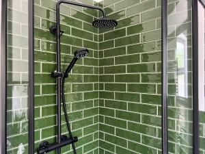 una doccia con piastrelle verdi su una parete di Mushroom Cottage a Ferndale
