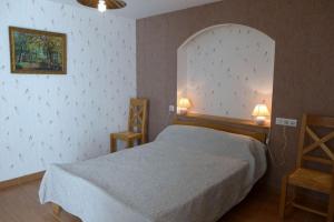 - une chambre avec un lit et deux chaises dans l'établissement Les jonquilles, à Vignes-la-Côte