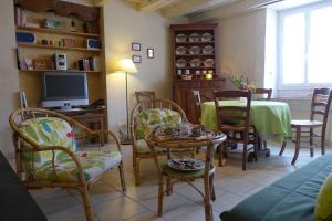 ein Wohnzimmer mit Tisch und Stühlen und einem Fernseher in der Unterkunft La maison de gabrielle in Giey-sur-Aujon + 8 Fotos