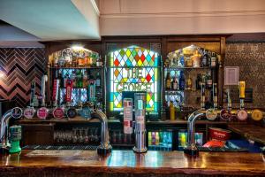 a bar with a counter with a lot of alcohol at George of Piercebridge in Piercebridge +93 photos