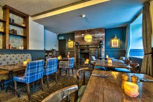 a restaurant with wooden tables and chairs and a fireplace at George of Piercebridge in Piercebridge