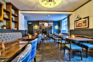 a restaurant with tables and chairs and a fireplace at George of Piercebridge in Piercebridge +76 photos