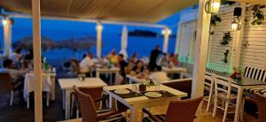 a restaurant with tables and chairs with a view of the ocean at Sky & Sea 3 in Kato Daratso