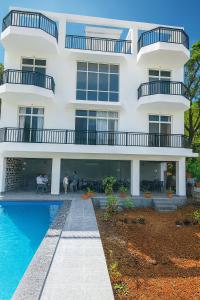KolvanにあるHemgiri - 6BHK Pool Garden Luxury Villa Girivan Mulshi near Pune Mumbaiの白い建物(目の前にスイミングプールあり) +13枚の写真