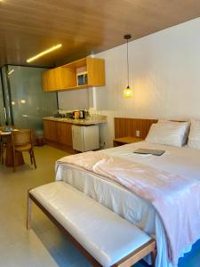 a bedroom with a large bed and a kitchen at Atins Beach Studios - Charmoso e Aconchegante in Atins +4 photos