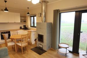 SulbiAatrium Kinnisvara Sulbi village Private Nature的配有桌子和壁炉的厨房和餐厅