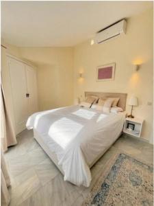 a bedroom with a large white bed and a rug at Pinos de Calahonda duplex in Sitio de Calahonda +34 photos