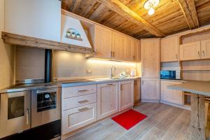 kuchnia z białymi szafkami i drewnianym sufitem w obiekcie Ospitalità Diffusa Laste Dolomites Cèsa del Bèrba Jaco w mieście Colle Santa Lucia