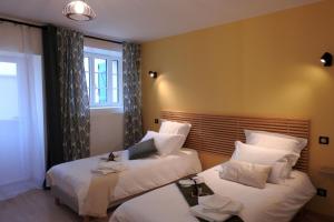 una camera d'albergo con due letti e una finestra di L'etape du general a Colombey-les-deux-Églises Altre 24 foto