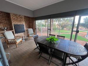 a living room with a table and chairs and a television at 39 Shone GH in Postmasburg