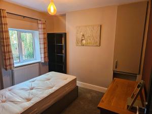 een slaapkamer met een bed en een tafel erin bij Tastefully decorated modern home in Nantwich