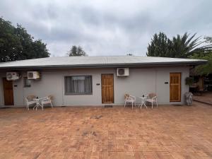 a white house with chairs and a table in front of it at 39 Shone GH in Postmasburg