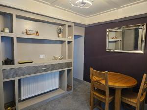 een eetkamer met een tafel en een spiegel bij Tastefully decorated modern home in Nantwich +6 foto's