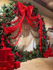 een kerstkrans met een rood lint en cadeautjes bij Family house in Druskininkai