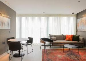 a living room with a couch and tables and chairs at Amazing 2Bdrm penthouse in JLM with balcony and view - פנטהאוז ירושלים in Jerusalem