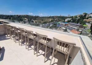 a row of chairs sitting on top of a roof at Amazing 2Bdrm penthouse in JLM with balcony and view - פנטהאוז ירושלים in Jerusalem