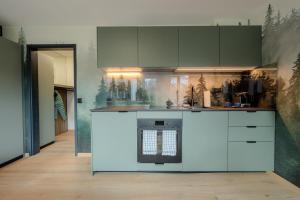 Una cocina con gabinetes blancos y un horno. en Collina Forest Design-Studio by Arosa Vacations, en Arosa