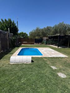 a swimming pool in a yard with a fence at Osvaldo Day Cabin with Pool in Albardón