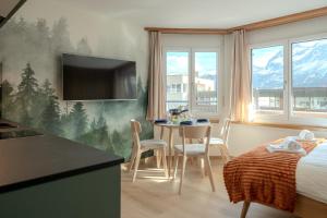 Un dormitorio con una cama y una mesa con sillas. en Collina Forest Design-Studio by Arosa Vacations, en Arosa 20 fotos más