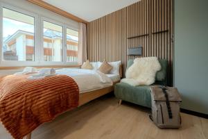 a bedroom with a bed and a chair and a window at Collina Forest Design-Studio by Arosa Vacations in Arosa