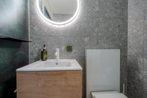 Un baño con lavabo, espejo e inodoro. en Collina Forest Design-Studio by Arosa Vacations, en Arosa