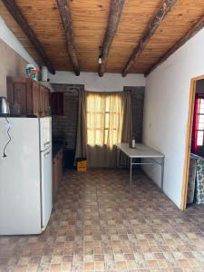 a kitchen with a white refrigerator and a table at Osvaldo Day Cabin with Pool in Albardón