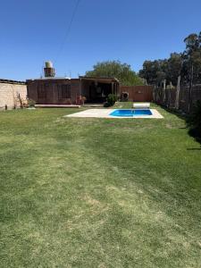 a yard with a swimming pool and a fence at Osvaldo Day Cabin with Pool in Albardón +4 photos