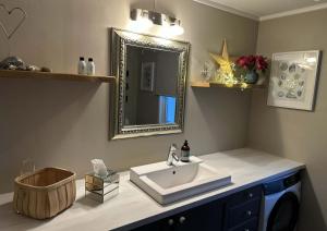 een badkamer met een wastafel en een spiegel bij Herb Farm Guesthouse in Senja