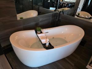 a bath tub in a bathroom with two sinks at Motel Rimouski in Rimouski
